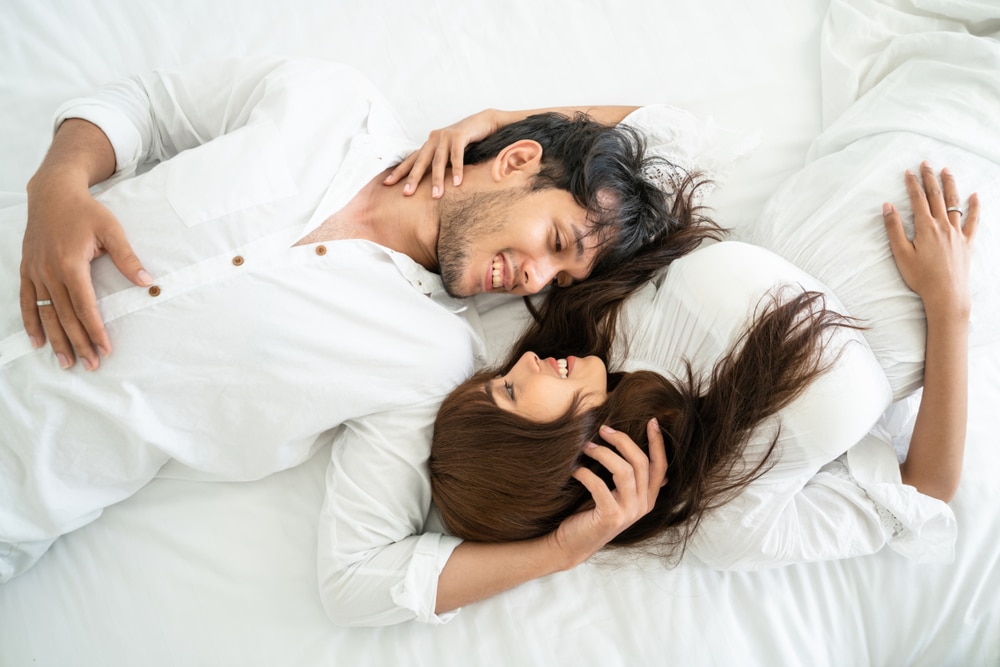 Happy young couple relaxing in home bedroom after waking up in the morning - The Libra Man With Cancer Rising