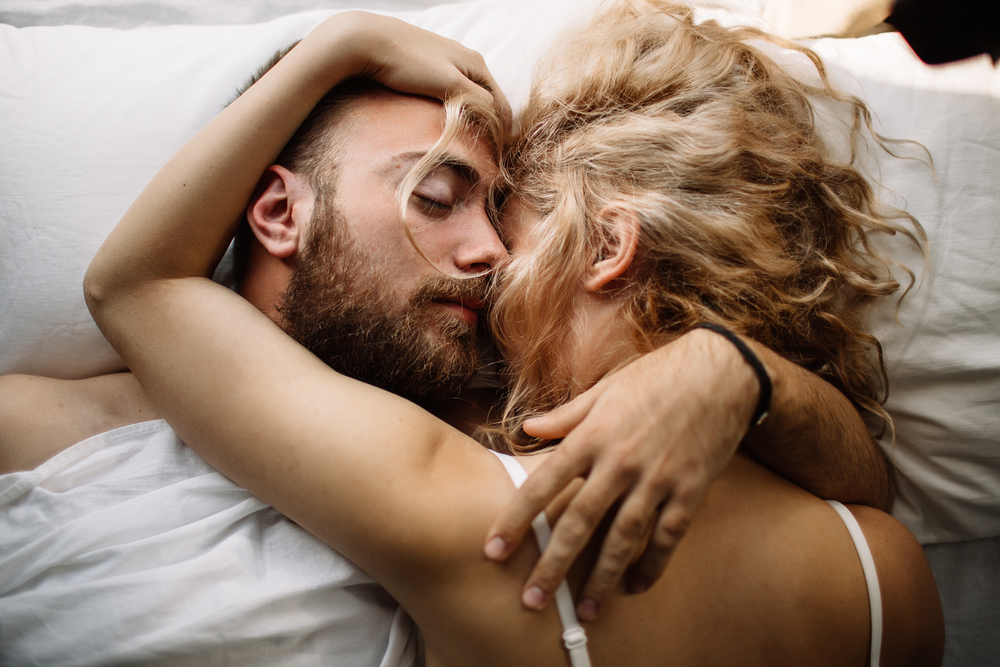 Pretty loving couple is luxuriating in bed together - The Libra Man with Libra Rising